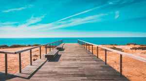 beach bench boardwalk clouds